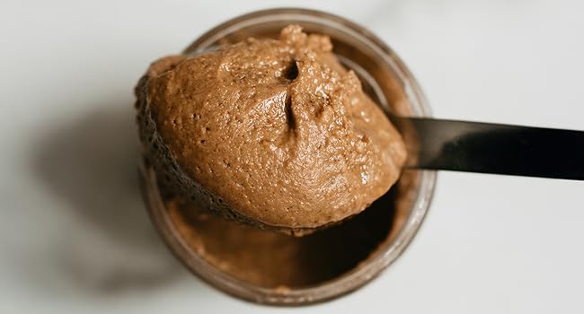 A spoonful of Nutty Novelties Wild Espresso peanut butter from an open jar